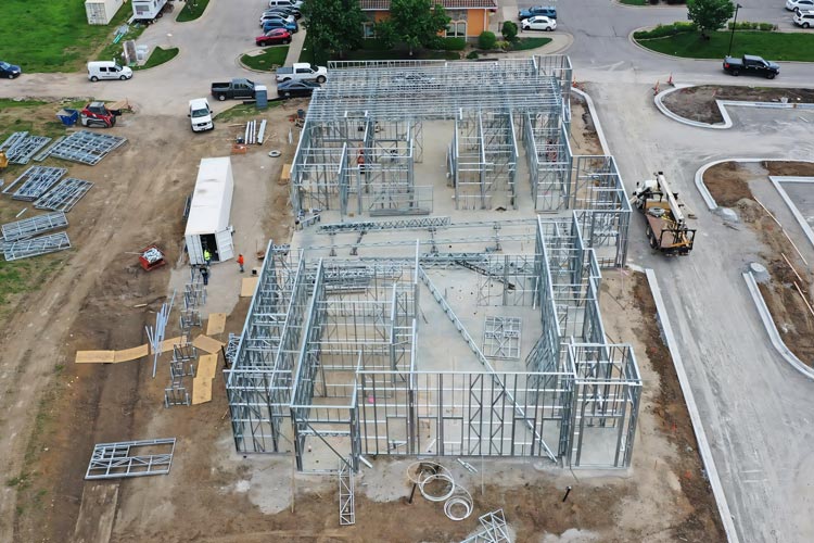 Mobile cold formed steel construction site using onsite steel framing machines for LGSF. Light gauge steel framing built with mobile factory technology.