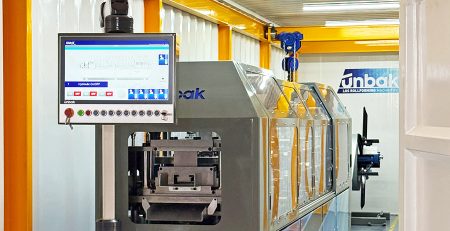 UNBAK steel framing machine inside container factory, producing light gauge steel profiles for prefabricated building and modular construction projects.