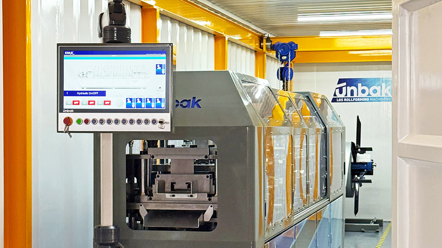 UNBAK steel framing machine inside container factory, producing light gauge steel profiles for prefabricated building and modular construction projects.
